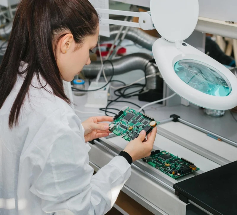 Technician inspecting a printed circuit board