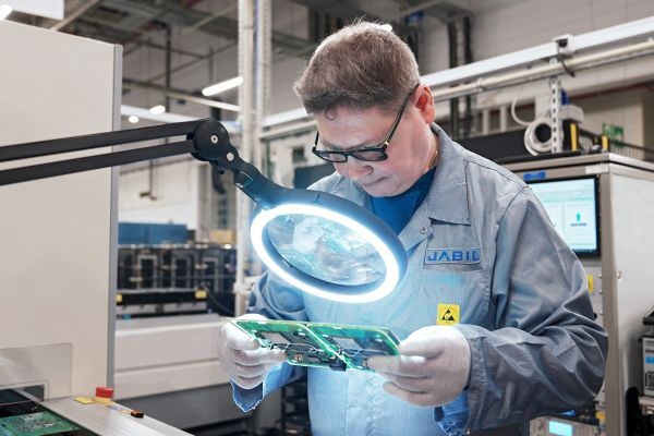 Electronics engineer inspecting an assembled PCB
